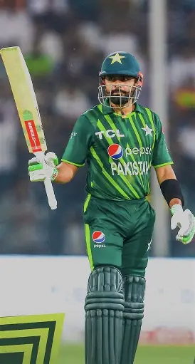 Pakistani cricket captain holding bat aloft after scoring a fifty in a T20 match
