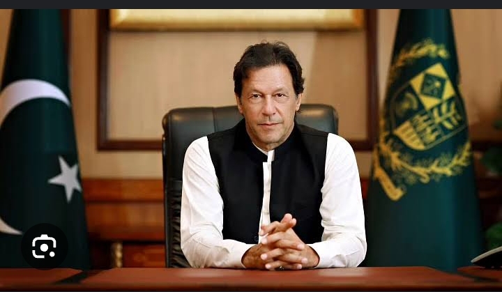 Imran Khan is seated at his office in formal attire
