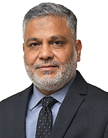  Usman Ullah in an official indoor setting wearing a formal suit and tie.