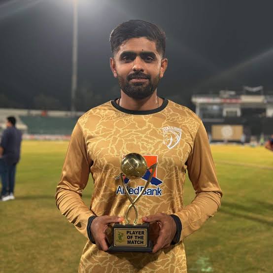 Babar Azam wearing yellow holding a trophy