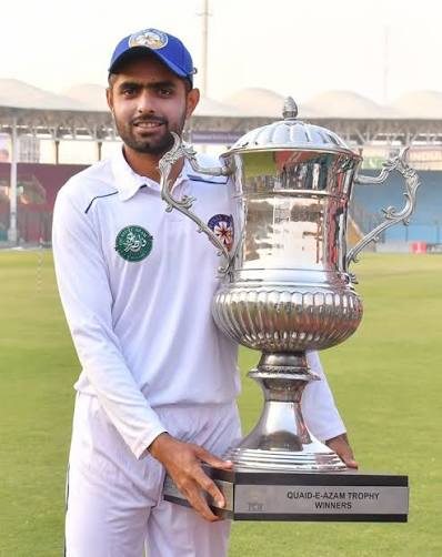 Babar Azam holding a cricket trophy
