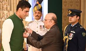 Arshad Nadeem, Pakistani javelin thrower, holding a gold medal on the podium during an international athletics awards ceremony.