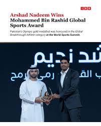 Arshad Nadeem, Pakistani javelin thrower, holding a gold medal on the podium during an international athletics awards ceremony.