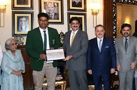 Arshad Nadeem, Pakistani javelin thrower, holding a gold medal on the podium during an international athletics awards ceremony.