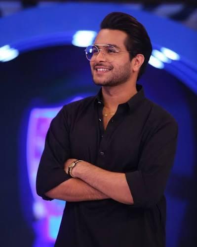 Asim Azhar, Pakistani singer and actor, smiling confidently while performing or posing for a photoshoot.
