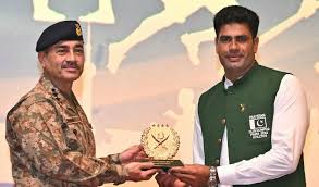 Arshad Nadeem, Pakistani javelin thrower, holding a gold medal on the podium during an international athletics awards ceremony.