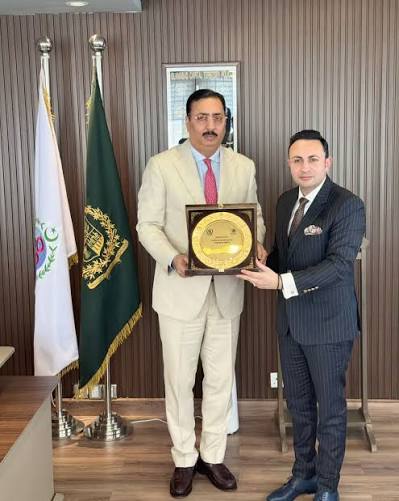 Sardar Yasir Ilyas receiving an award wearing a grey suit