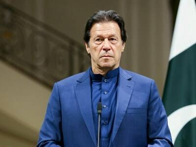 Imran Khan in a formal portrait, smiling confidently
