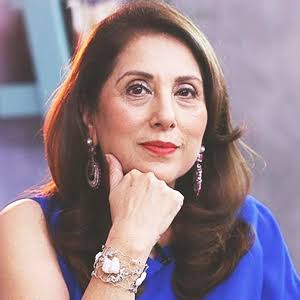 A close-up portrait of Pakistani actress Samina Peerzada, who has brown hair and is wearing a blue top, with her chin resting on her hand.
