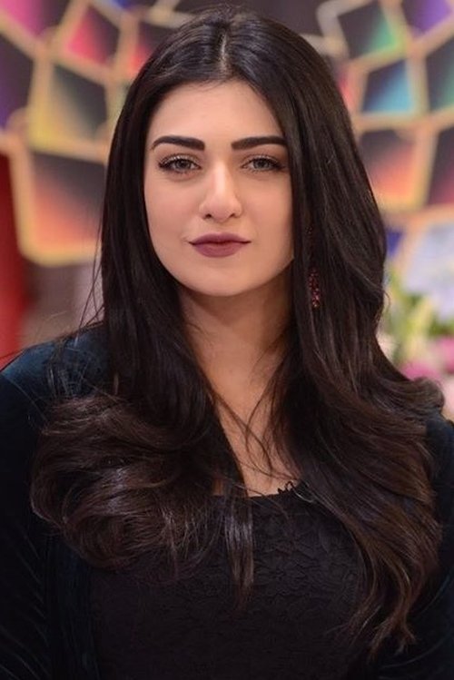 A portrait of Pakistani actress Sarah Khan with long dark hair, wearing a dark top, looking at the camera.
