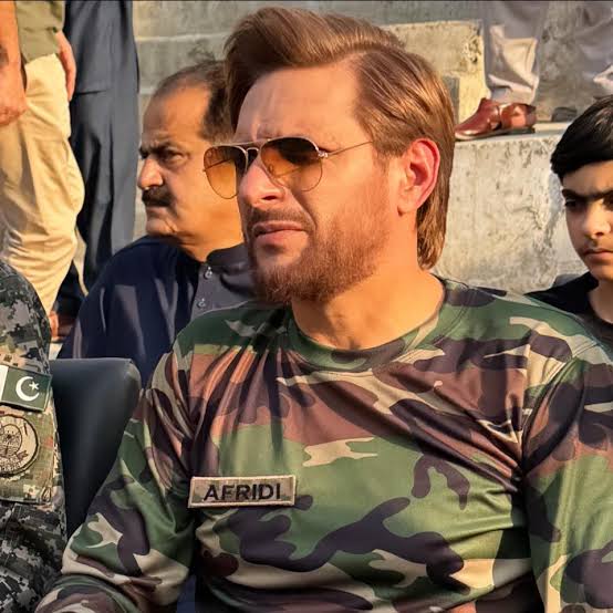 Shahid Afridi smiling in a formal portrait