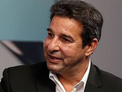 A portrait of former Pakistani cricketer Wasim Akram wearing a black suit jacket and a white shirt.
