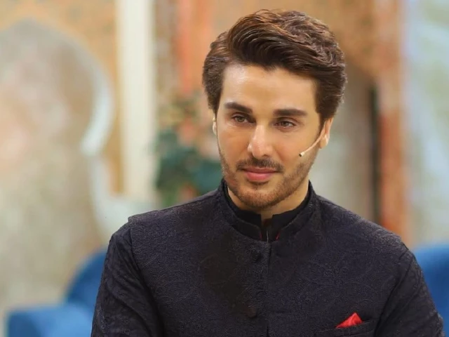 A portrait of Pakistani actor and host Ahsan Khan, who has a beard and brown hair, wearing a black embroidered jacket.
