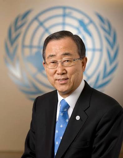  Official portrait photograph of Ban Ki-moon wearing glasses and a black suit with blue tie, standing in front of the United Nations emblem
