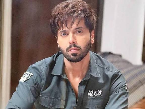 Fahad Mustafa smiling confidently at the camera
